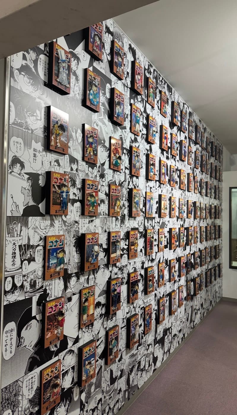 Alle Detective-Conan-Manga-Bände an einer Wand in der Gōshō Aoyama Manga Factory in Hokuei