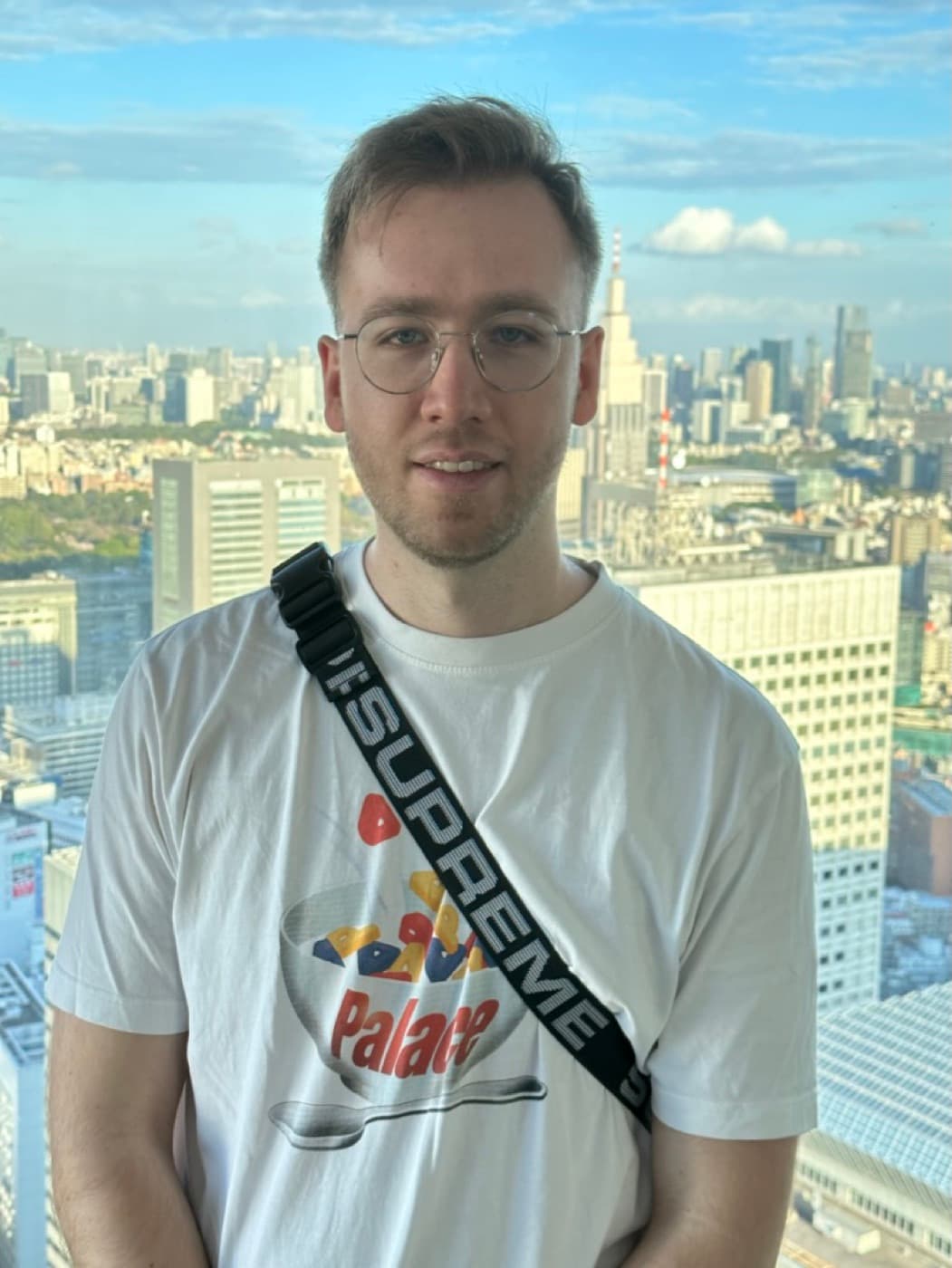 Person auf der Aussichtsplattform des Tocho, dahinter die Hochhäuser von Shinjuku hinter der Fensterfront