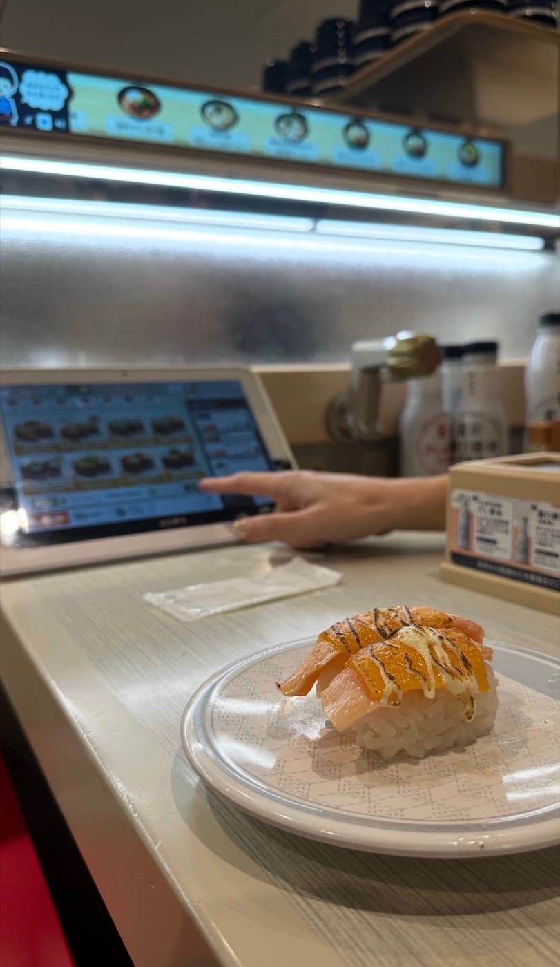 Teller auf dem Förderband einer japanischen Kaiten-Sushi-Kette