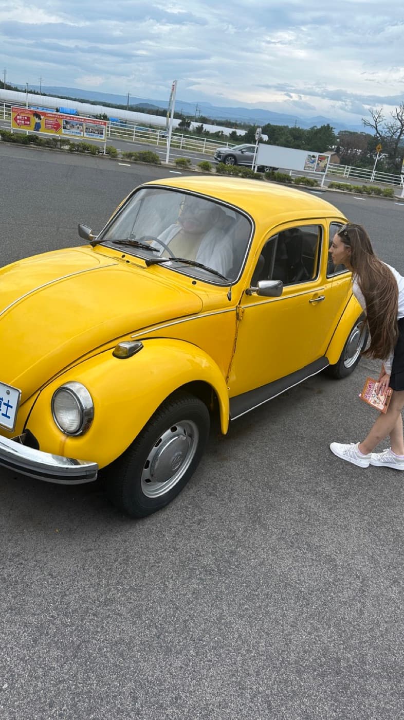 Gelber VW Käfer im Stil des Autos aus Detective Conan, als Ausstellungsstück auf einem Parkplatz