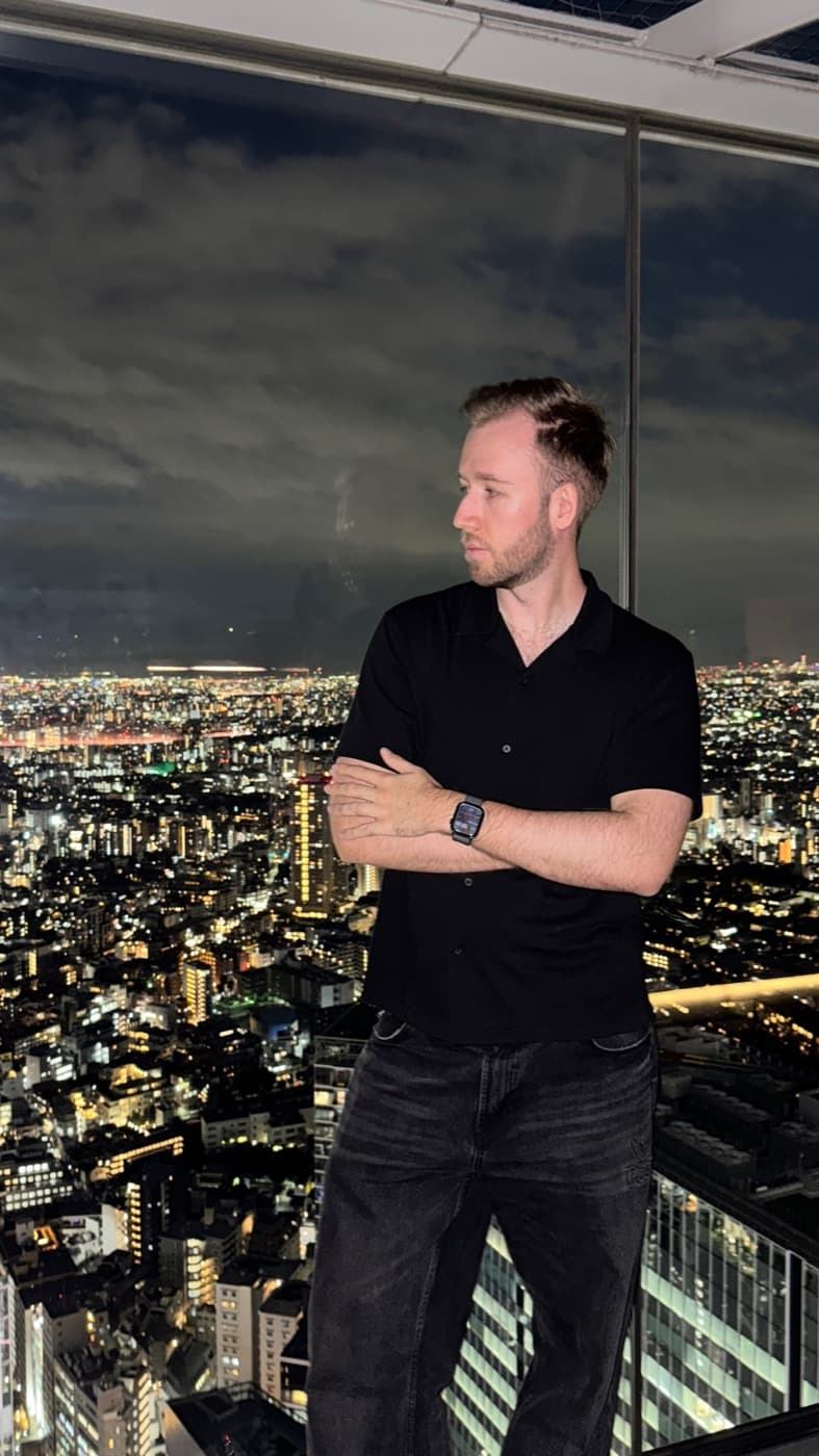 Person vor dem nächtlichen Lichtermeer von Tokio, aufgenommen in der Innengalerie