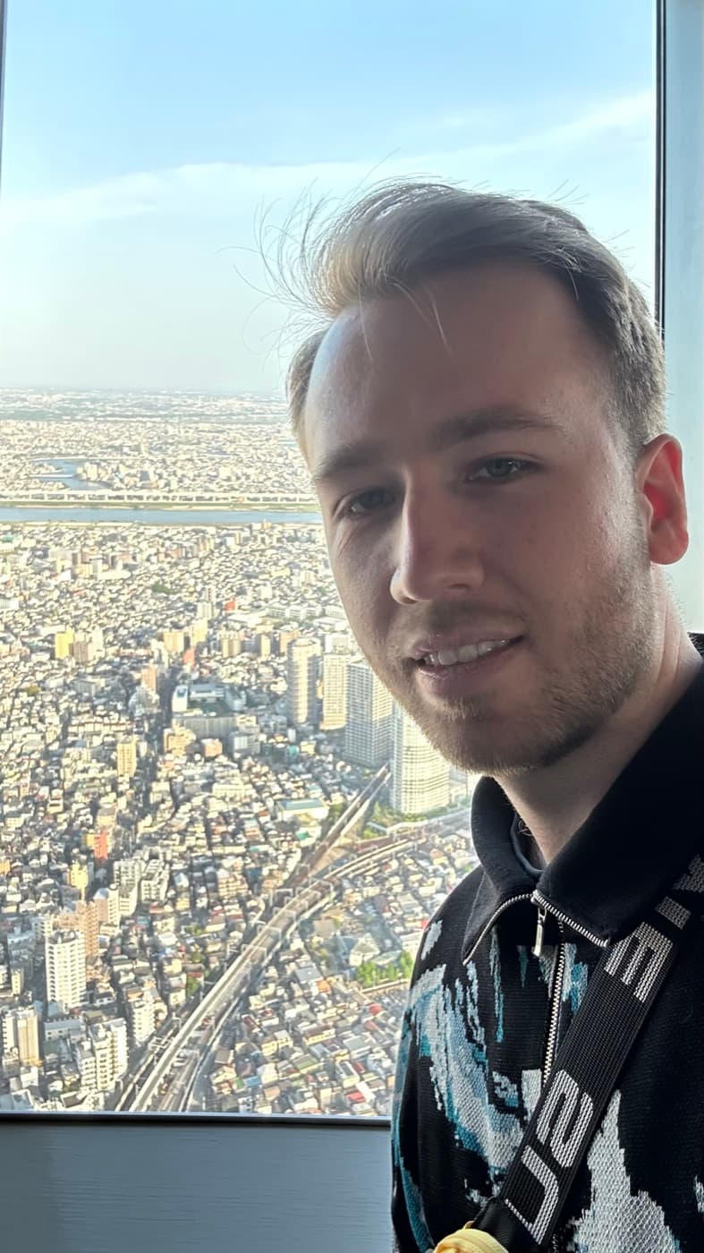 Selfie an der Fensterfront des Tembo Deck mit Blick über das flache Wohngebiet von Tokio